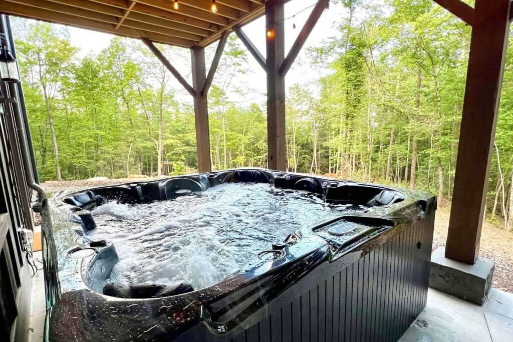 Bubbling hot tube on a patio overlooking the woods.