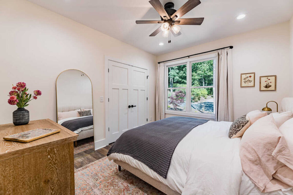 Bedroom with upholostered king bed with blush pink pillow cases.