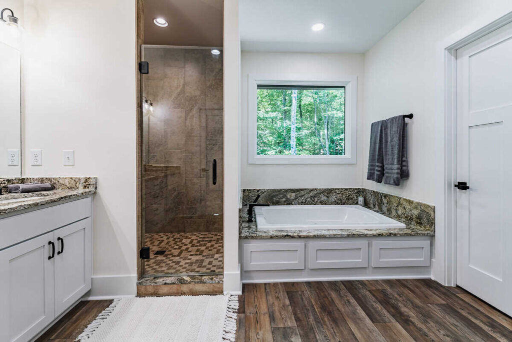 Large bathroom with bathtub, tiled shower, and double vanity.