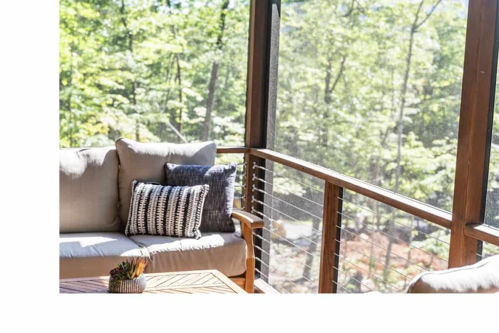 Outdoor couch with black and white throw pillows on a sunny deck.