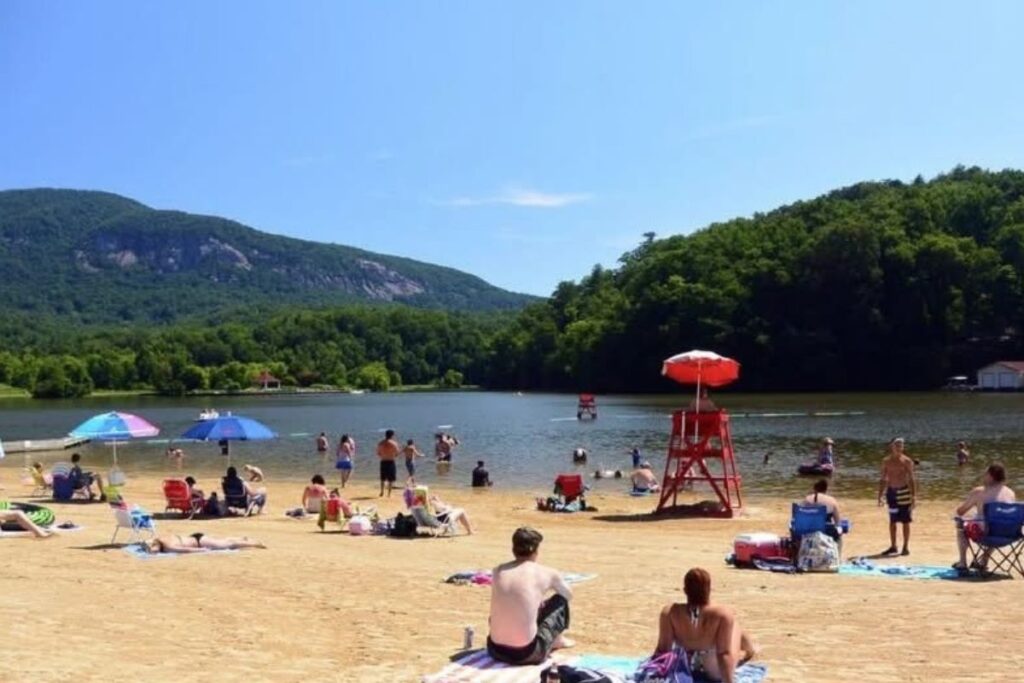 People sitting on the beach at Rumbling Bald Resort in Lake Lure, North Carolina.
